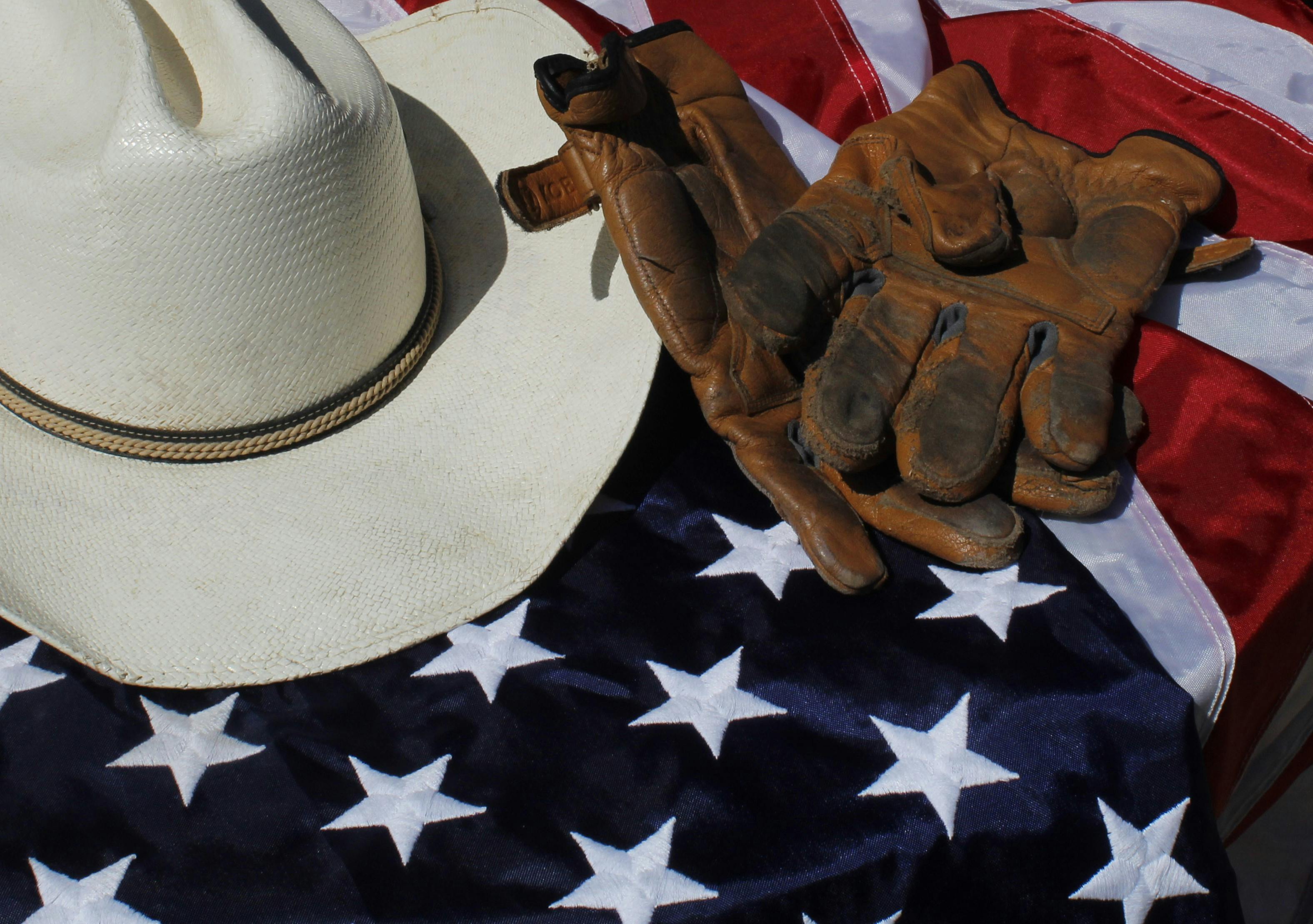 Cowboy hat, work gloves, and American flag
